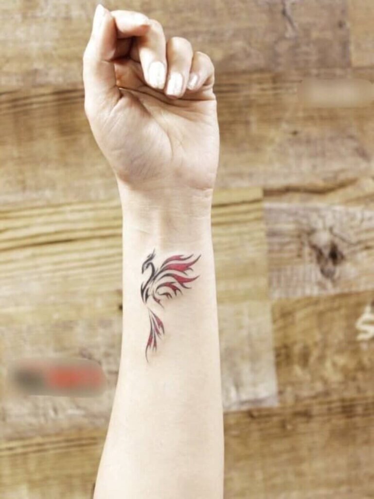 A colorful phoenix tattoo on the wrist