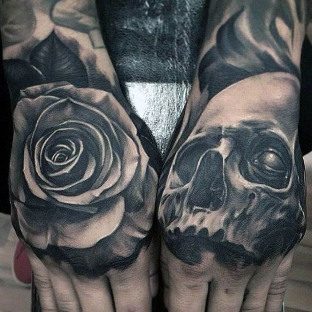 Black and gray rose tattoo on the hand with skeleton tattoos on the fingers